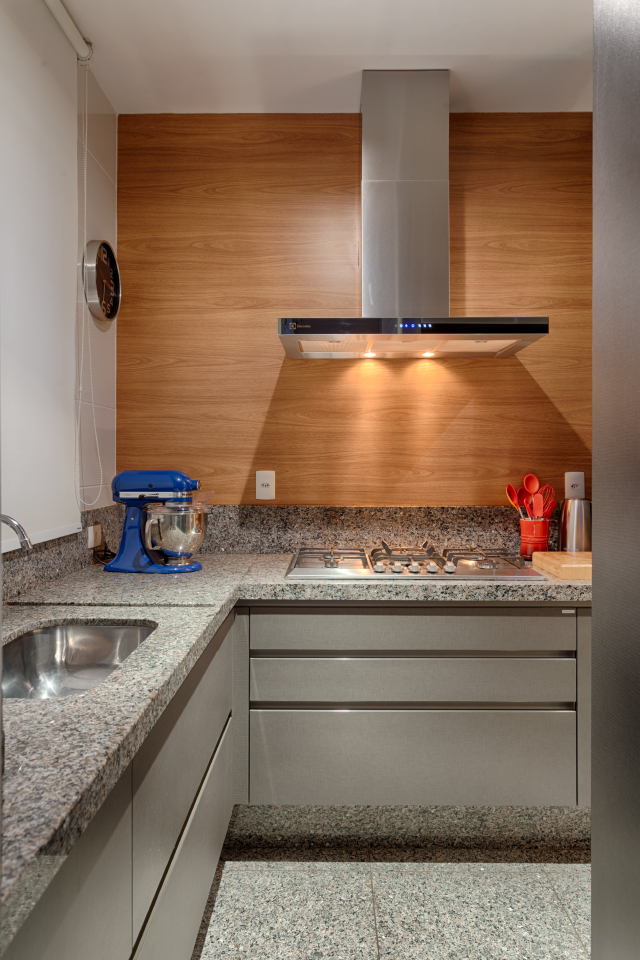 Cozinha de apartamento pequeno realizada pela equipe renata basques. Repare na utilização do espaço abaixo da bancada para armazenar os utensílios domésticos. 
